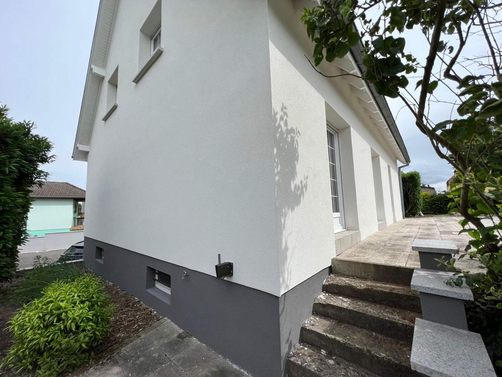 Maison blanche avec soubassement gris