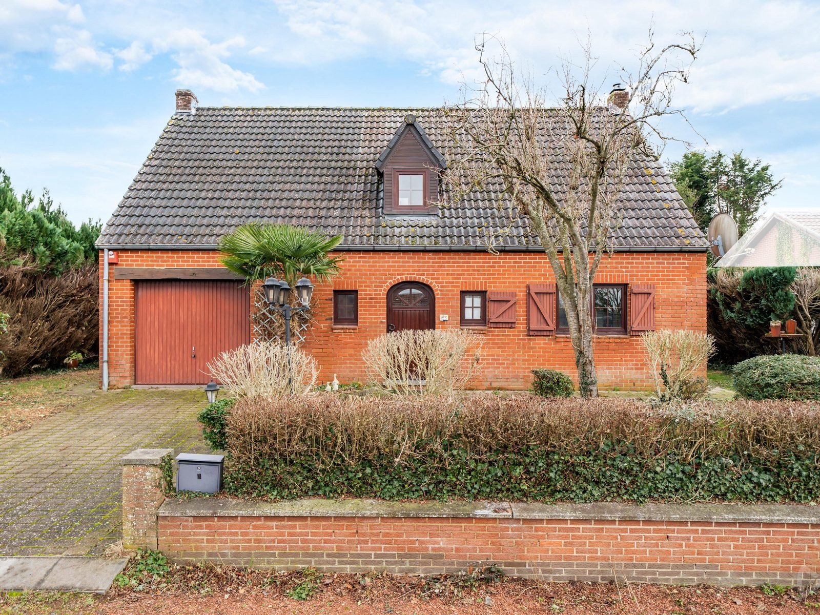 Maison en brique rouge sous un toit de tuiles