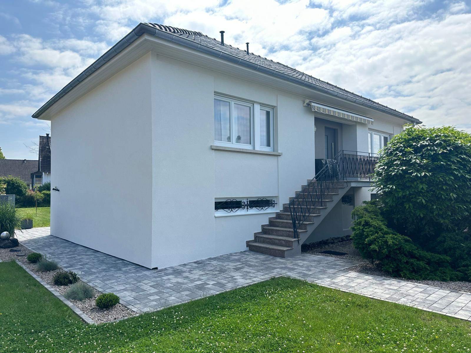 Maison à étage refaite en enduit blanc, avec escalier extérieur