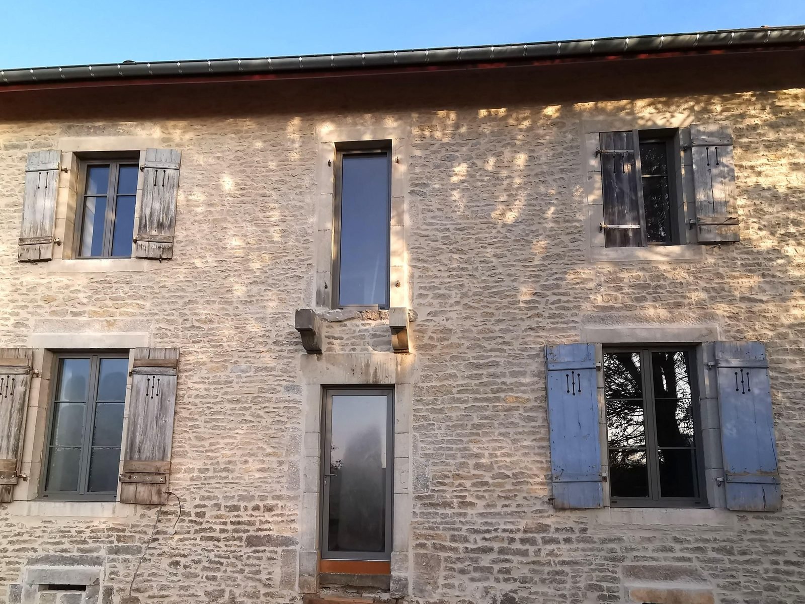 Maison en pierre aux volets bleus