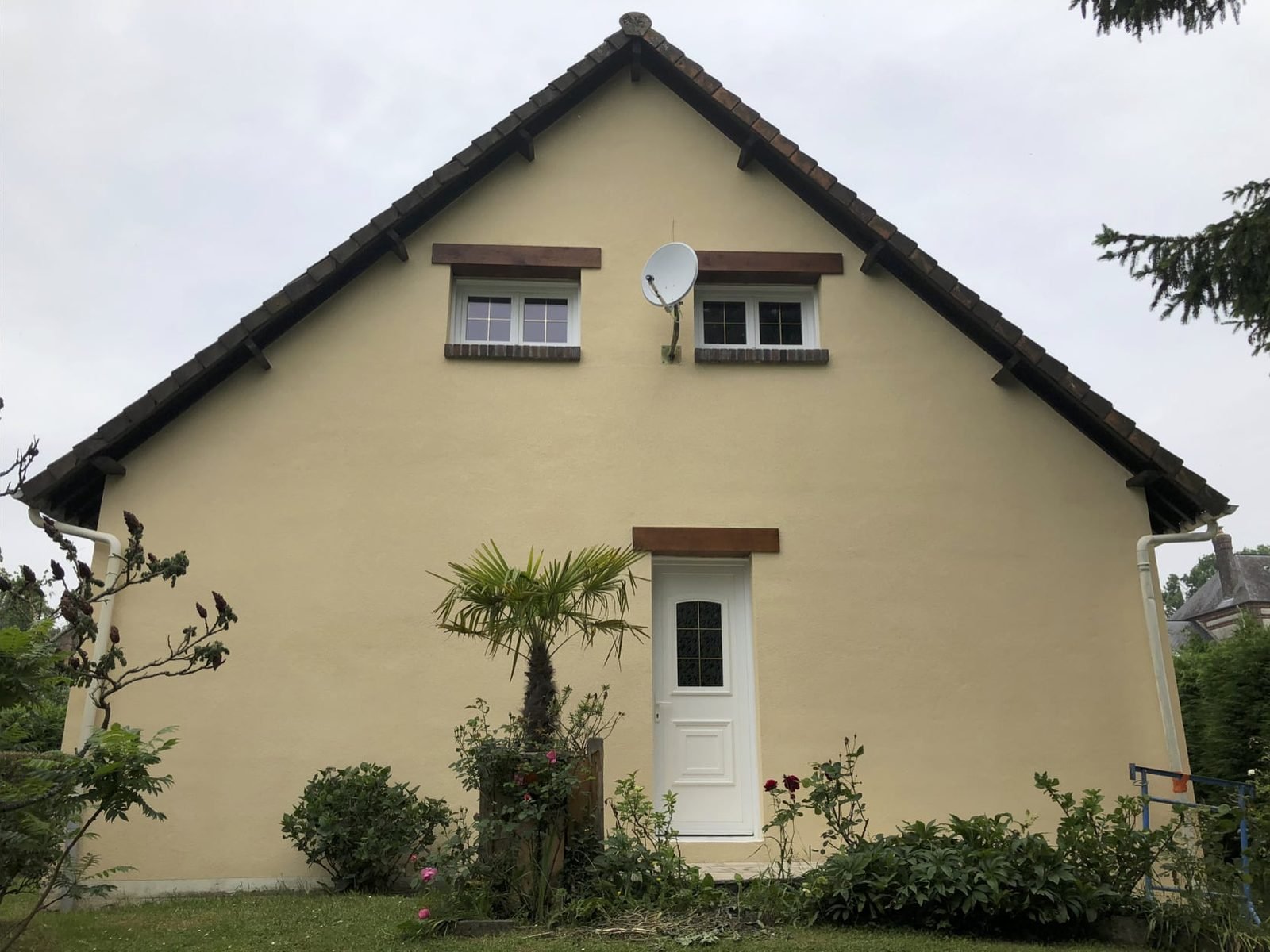 Pignon enduit en beige d'une maison individuelle