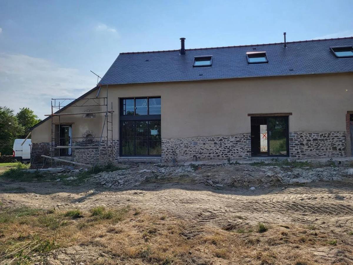Chantier d'enduit à la chaux au-dessus d'un soubassement en pierre