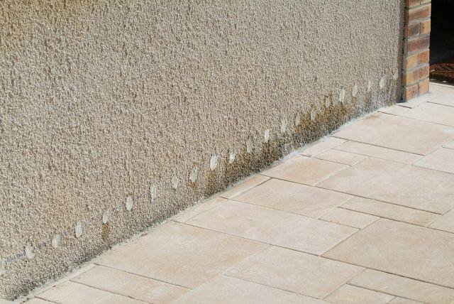 Trous d'injection alignés en pied de mur